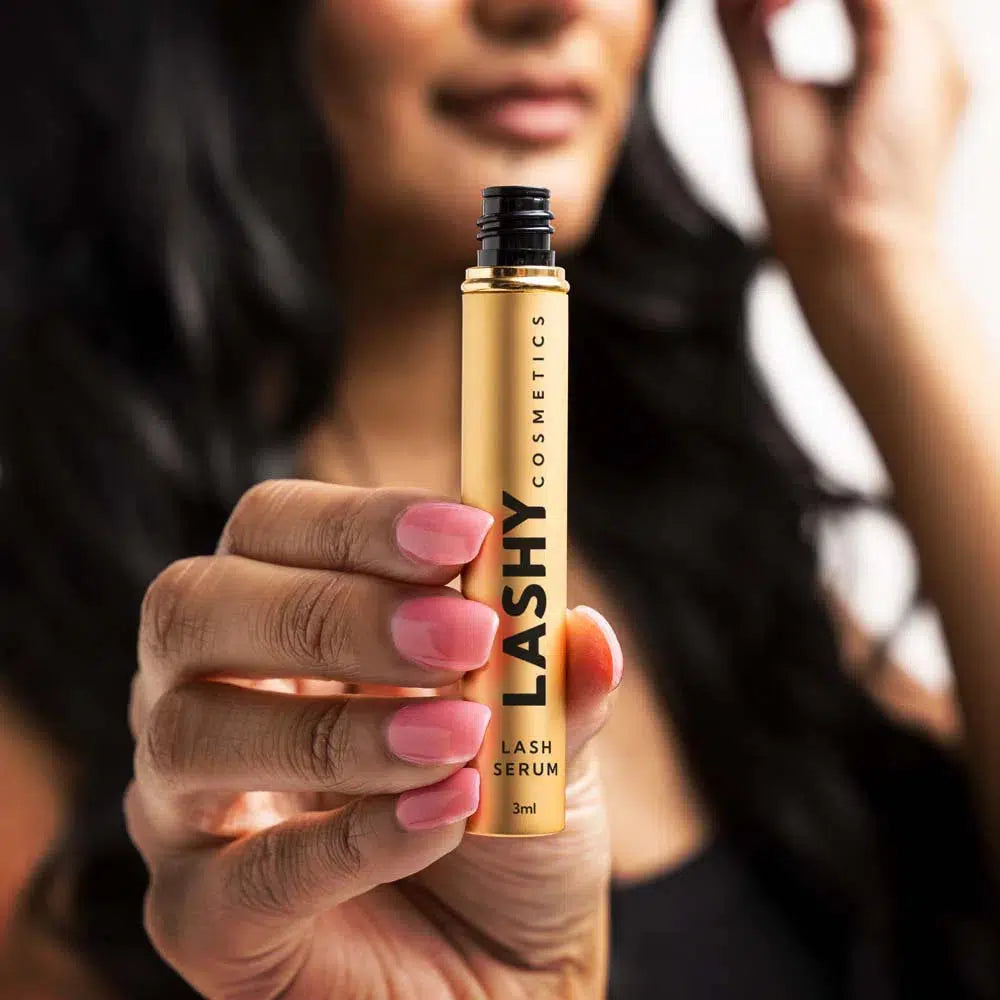 Close-up of a Lashy Cosmetics model holding the Lashy eyelash serum bottle with perfectly manicured nails, showcasing the Lashy brand clearly.